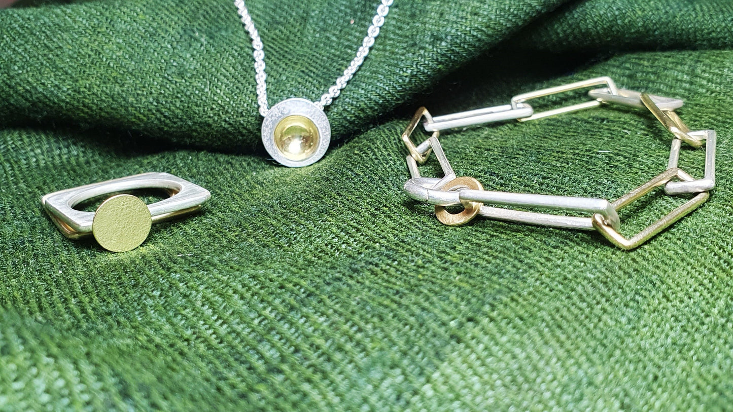 Silver and gold jewellery featuring: Orbit pendant, silver with gold cup; square ring with gold moon; and, orbit bracelet #BarbaraSpenceJewellery