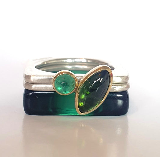 Set of three square rings. Two thin silver: one with a dark green marquise tourmaline, one with a vivid green cabochon emerald. Perspex ring in deep bottle green. #BarbaraSpenceJewellery