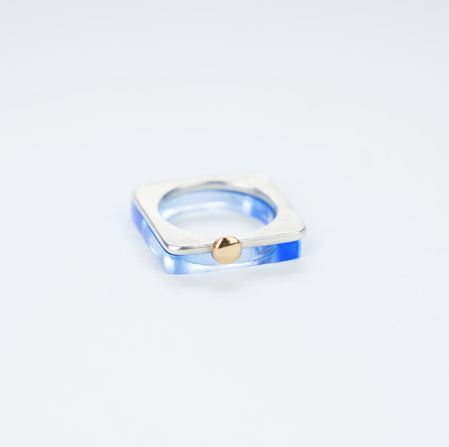 A square ring in silver with a gold ball.