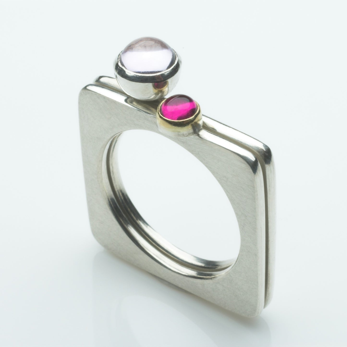 A square silver ring with a pretty cabochon set in gold.