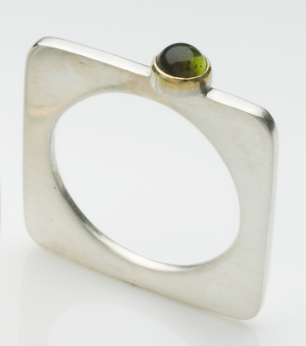 A square silver ring with a pretty cabochon set in gold.