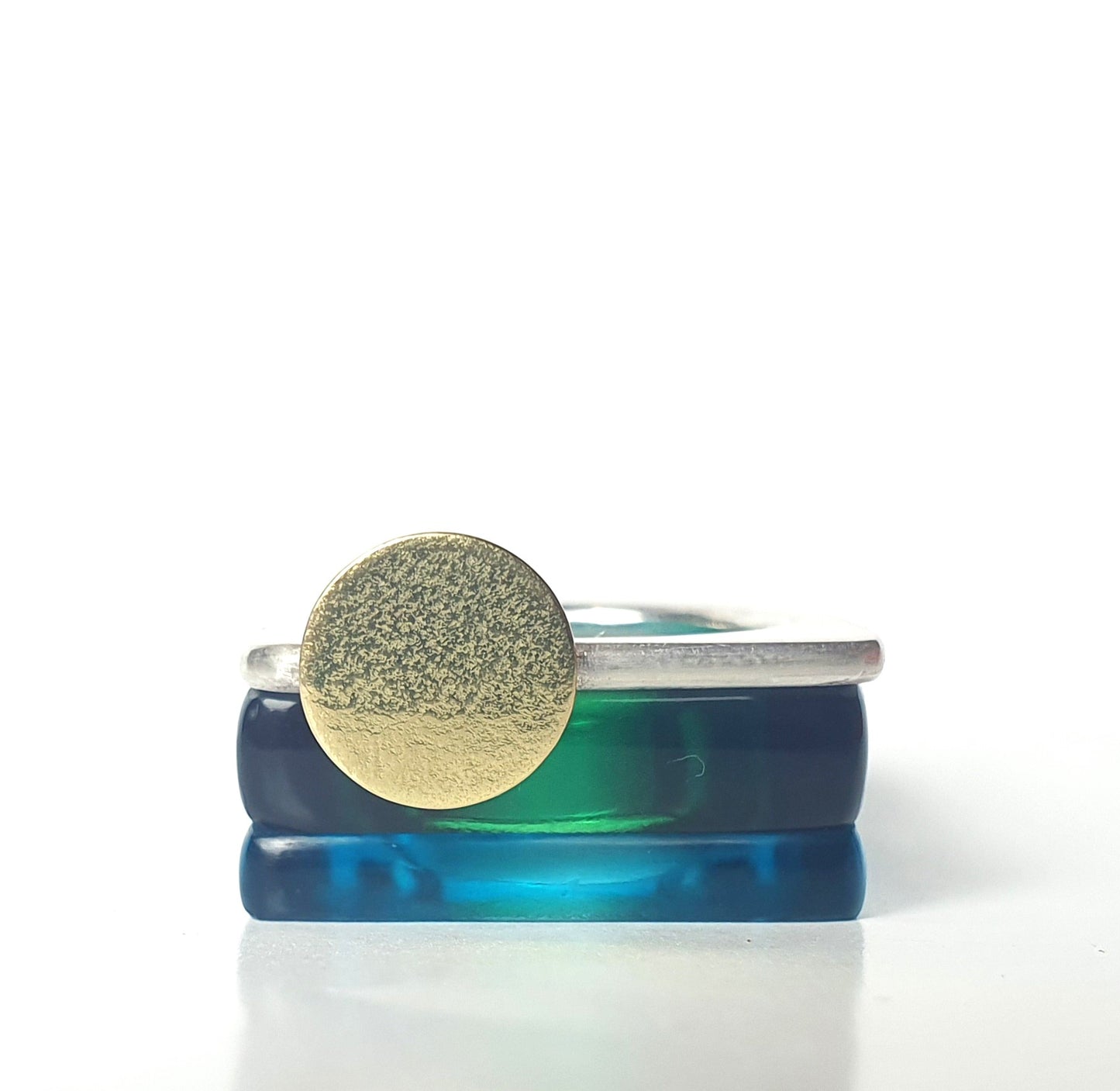 Two perspex rings in bottle green and azure with a silver ring decorated with a textured gold moon.
#BarbaraSpenceJewellery