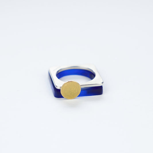 A square ring in silver with a gold disc or 'Moon'.