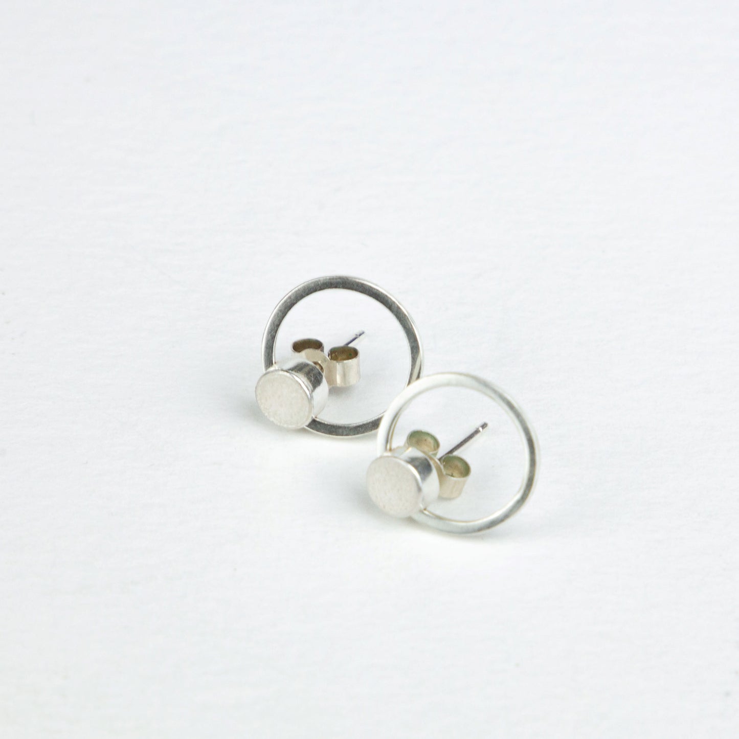 Orbit earrings, with a textured disc in silver and gold and a larger orbiting ring in silver