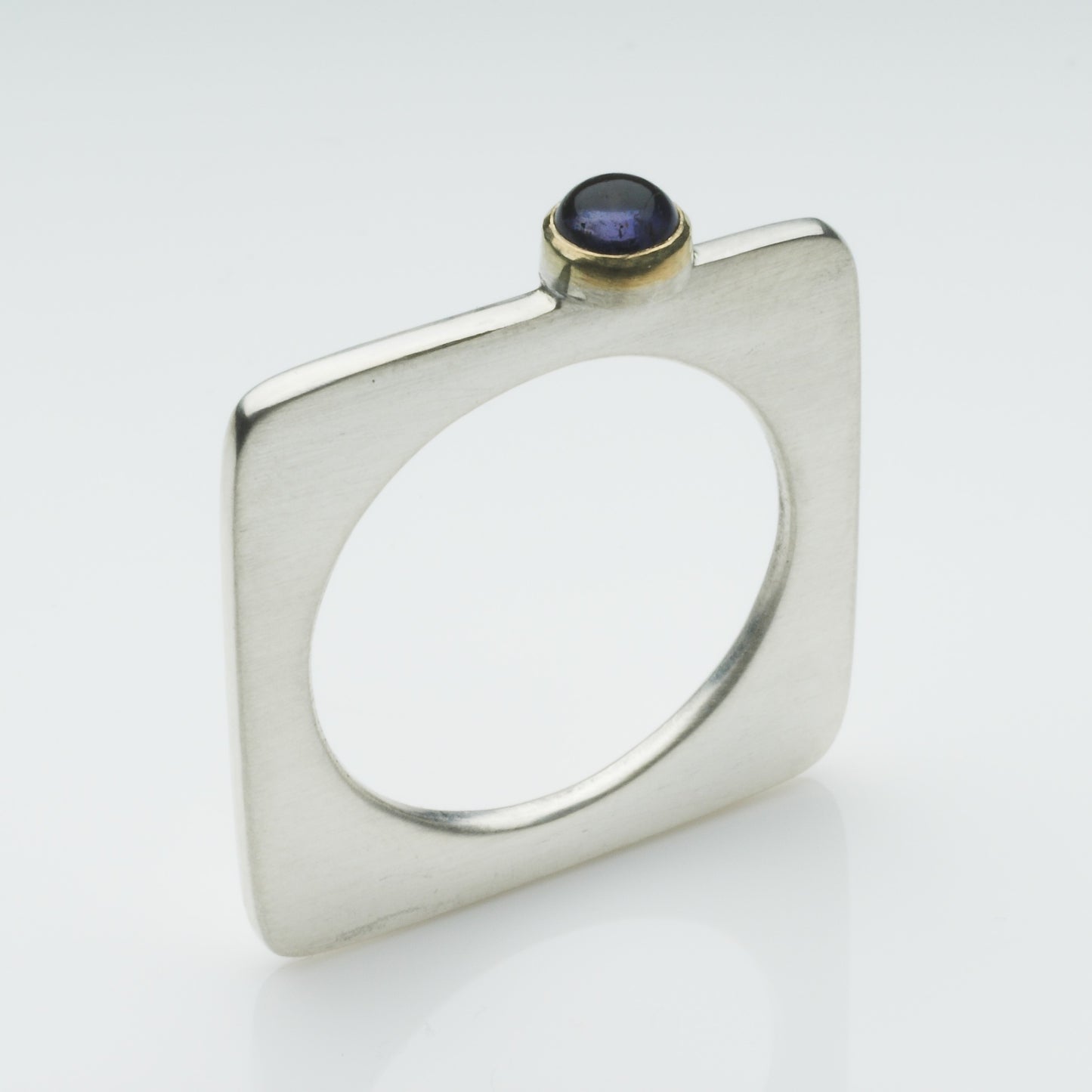 A square silver ring with a pretty cabochon set in gold.