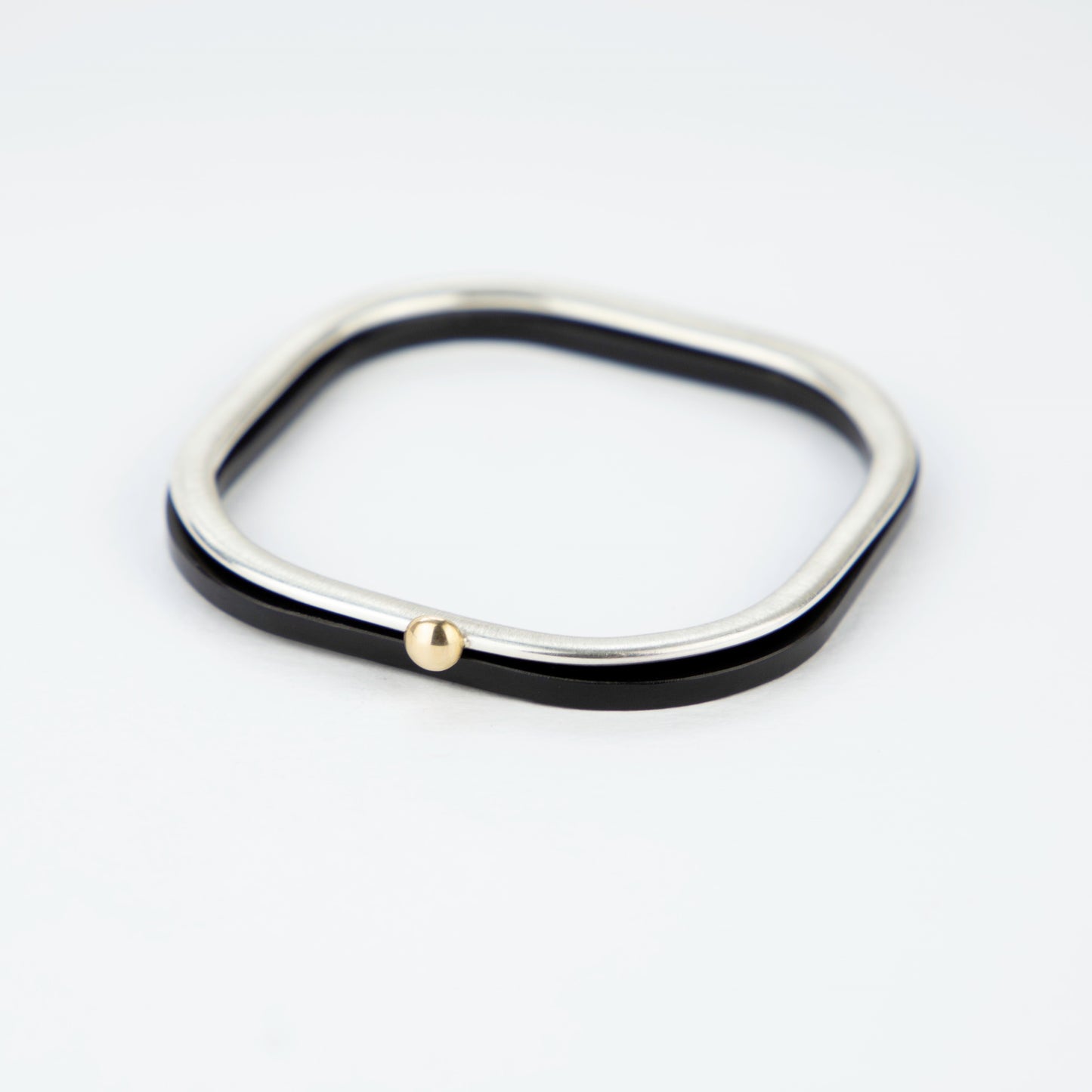 Square silver bangle with gold ball stacked with black acrylic bangle www.barbaraspence.co.uk
